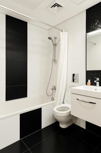 ドバイにあるDezire Delightのトイレとシャワー付きの白いバスルーム