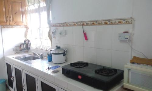 a kitchen with a stove and a sink at Bano Tourist Residence - 650 meters from Grand Bay Beach in Grand Baie