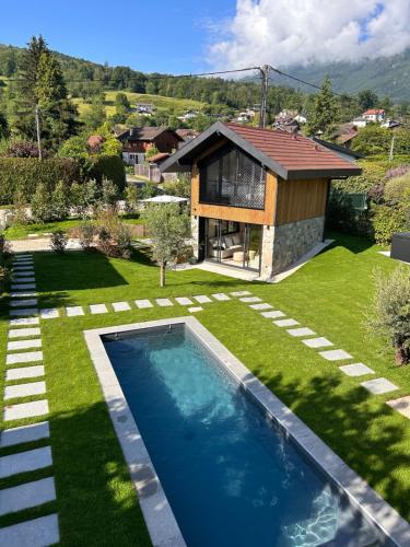 un cortile con piscina e una casa di La Villa 225 - Lac Annecy a Saint-Jorioz
