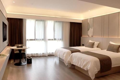 a hotel room with two beds and a television at Taiyi International Hotel in Wenzhou