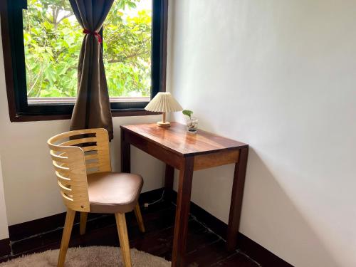 a desk with a chair and a lamp and a window at Isla Stays Siargao in General Luna