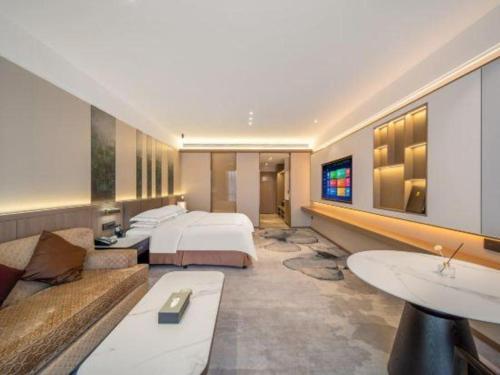 a hotel room with a bed and a couch at Northwest Petroleum Hotel in Ürümqi