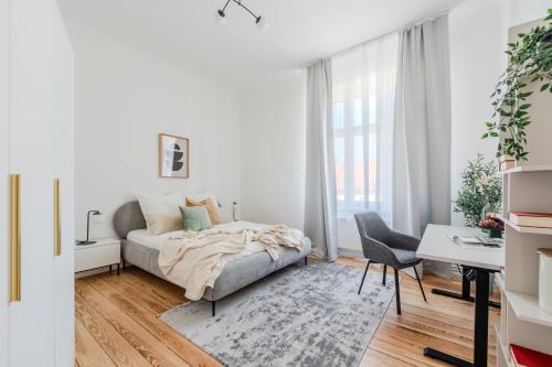 a white bedroom with a bed and a desk at Apartment am Holländischen Viertel in Potsdam