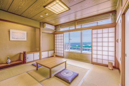 a room with a table and a large window at TAOYA Shirahama Senjyo in Shirahama