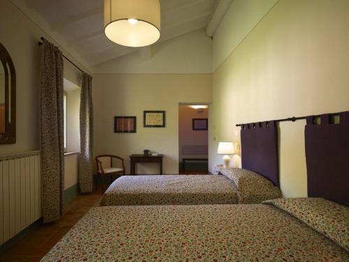 a hotel room with two beds and a table at B&B Palazzolo La Foce in Chianciano Terme