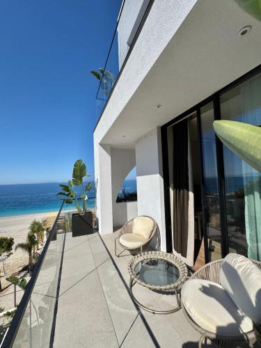 a balcony of a house with a view of the beach at Amarea Boutique Hotel in Dhërmi