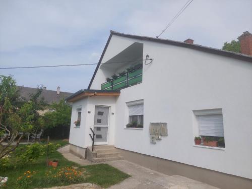 a white house with a window on the side of it at Kilátó Apartman ,upper floor of the house in Balatonfüred