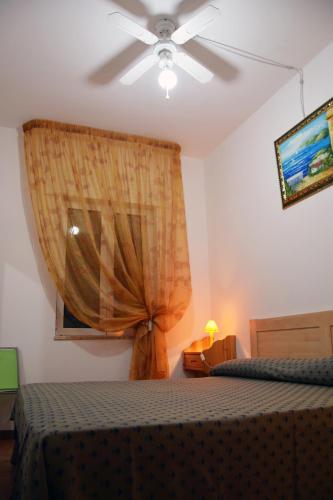 a bedroom with a bed and a window with a curtain at Camping Villaggio Pineta Al Mare in Specchiolla 