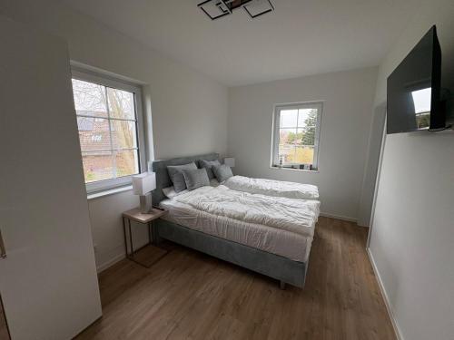 a small bedroom with a bed and two windows at Gartenstraße 22 Haus E Wohnung DG in Stick