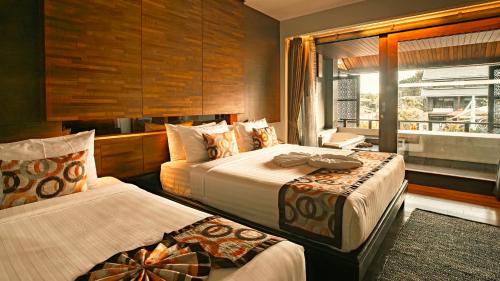 a hotel room with two beds and a window at Am Samui Palace in Lamai