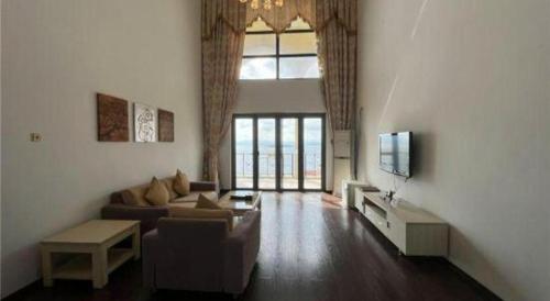 a living room with a couch and a tv at The Century Seaview Hotel in Shenzhen