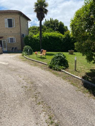 a bench sitting in the grass next to a house at Le Pervinche Affittacamere in Bastia Umbra