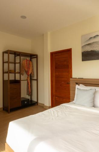 a bedroom with a white bed and a wooden cabinet at Caya Beach by Satori in Koh Phangan