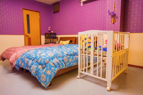 a bedroom with a bed and a purple wall at 犬山モダンルーム in Inuyama