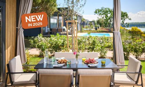 a table with food on it with a sign that reads new in at Aminess Planet Camping Holiday Homes Sirena in Novigrad Istria