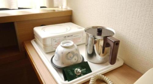 a counter with a coffee maker and a tea kettle at Hotel Route Inn Furukawa Ekimae in Osaki