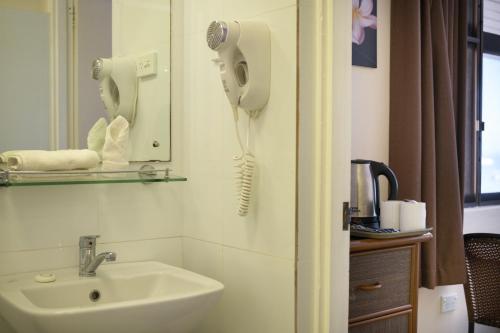 a bathroom with a sink and a hair dryer at Aquarius On The Beach in Nadi