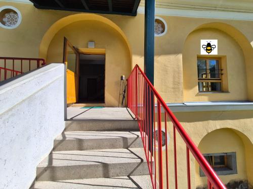 a stairway leading to a building with a red railing at appartement bumblebee in Sankt Lambrecht