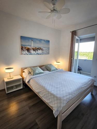 a bedroom with a bed with a lighthouse on the wall at Apartman TIA in Vir