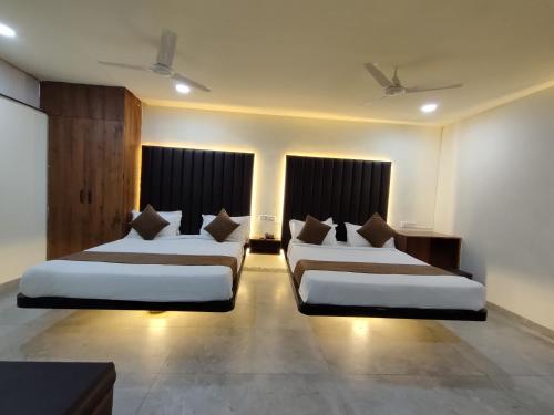 a hotel room with two beds in a room at Hotel Shivtara in Nānded