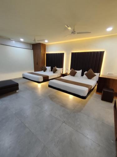 a bedroom with two beds in a room at Hotel Shivtara in Nānded
