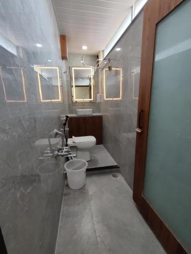 a bathroom with a toilet and a sink and a mirror at Hotel Shivtara in Nānded