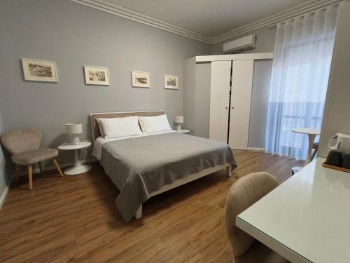 una camera da letto con un letto, un tavolo e delle sedie di Canfora 163 Cutaias apartment a Catania