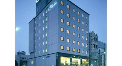 a tall gray building with a sign on it at Alpha Hotel Tokushima in Tokushima