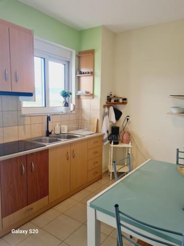 a kitchen with wooden cabinets and a sink and a window at IRIA Beach in Iria