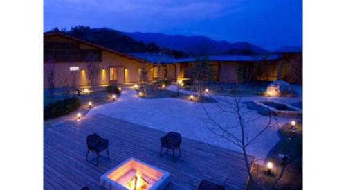 a patio with chairs and lights at night at Kyoto Keburikawa Hotel in Kameoka