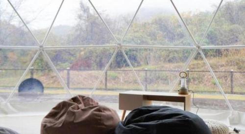 a person laying in bed in front of a window at Kyoto Keburikawa Hotel in Kameoka