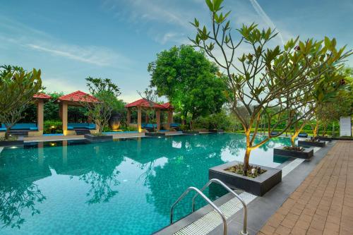 a swimming pool at a resort with trees at Novotel Imagicaa Khopoli in Khopoli