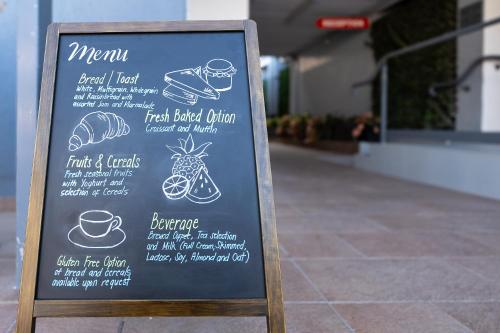 a menu sign in front of a restaurant at Vitina Studio Motel in Darwin