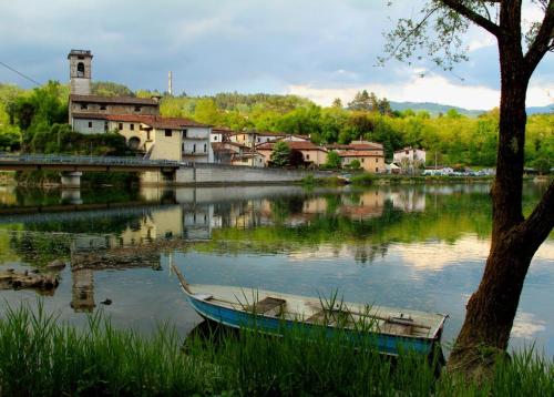 a boat sitting in the water next to a town at B&B Il Casale delle Pianacce in Castiglione di Garfagnana