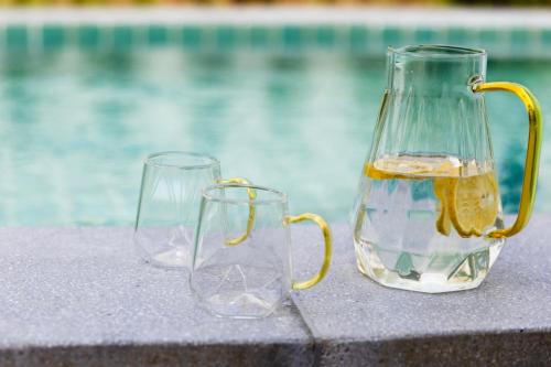 two glass vases sitting next to a swimming pool at Caya Beach by Satori in Koh Phangan