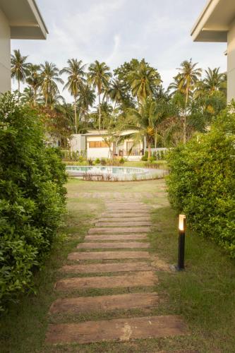 a path leading to a resort with palm trees at Caya Beach by Satori in Koh Phangan