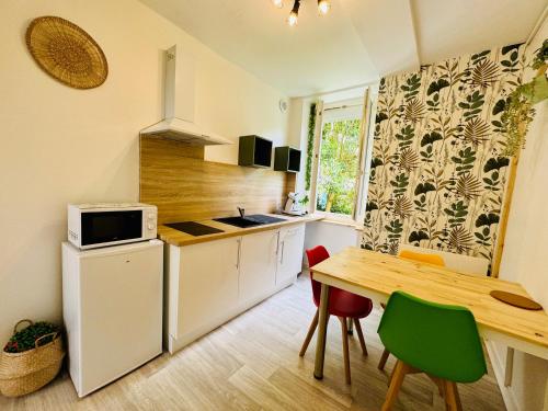 une petite cuisine avec une table et un micro-ondes dans l'établissement Le Mosaïque, à Périgueux