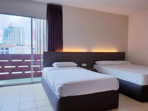 a hotel room with two beds and a large window at Champcity Hotel Sdn Bhd in Kuantan