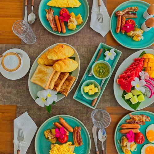 a table full of plates of food with breakfast foods at Anzhu Seamate Villa Samui in Amphoe Koh Samui