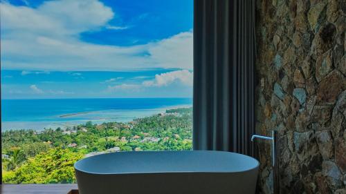 a bathroom with a tub and a large window at Anzhu Seamate Villa Samui in Amphoe Koh Samui