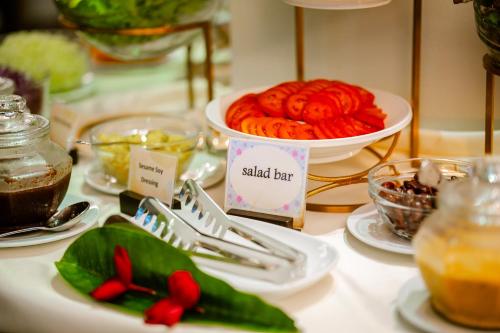 a table with plates of food and a bowl of food at Am Samui Palace in Lamai