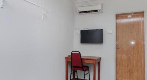 a room with a desk and a chair and a television at OYO 90120 MI Hotel Dungun in Dungun