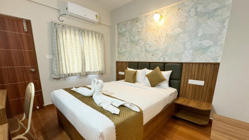 a hotel room with a bed with a towel on it at Dream Inn in Bengaluru