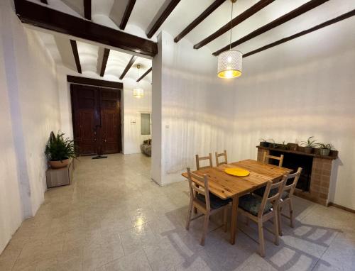 a dining room with a wooden table and chairs at Casa Naranja in Palma de Gandía