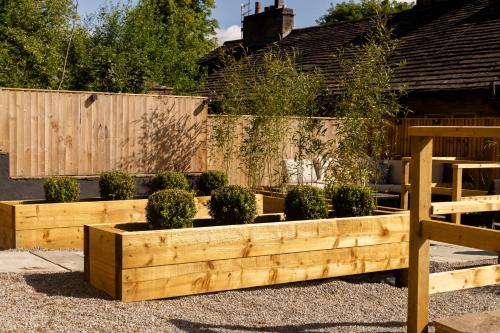 a garden with two wooden boxes with plants in it at The Wagon Shed in Sowerby Bridge