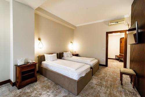 a hotel room with two beds and a table at Hotel AmaDeus in Focşani