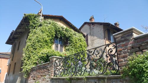 an ivy covered building with a iron fence at Borgo Archinto in Robecco sul Naviglio