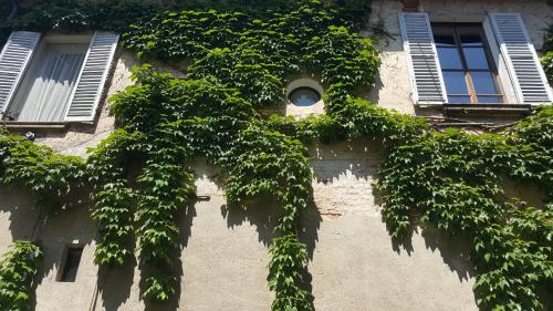 a building with ivy growing on the side of it at Borgo Archinto in Robecco sul Naviglio