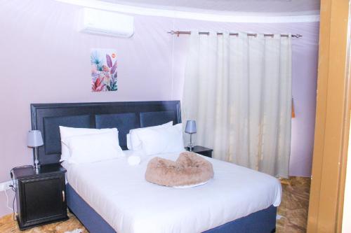 a bedroom with a bed with a heart pillow on it at Masiyabundu Guest House in Gaborone