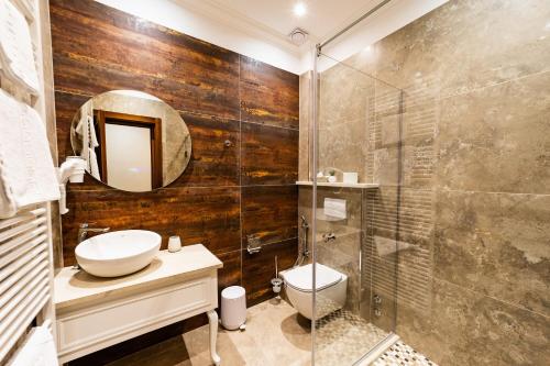 a bathroom with a toilet and a glass shower at Hotel AmaDeus in Focşani